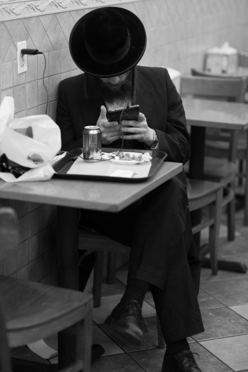 Satmar man using Tablet at restaurant in Williamsburg. Photo Credit: Mark Hanover