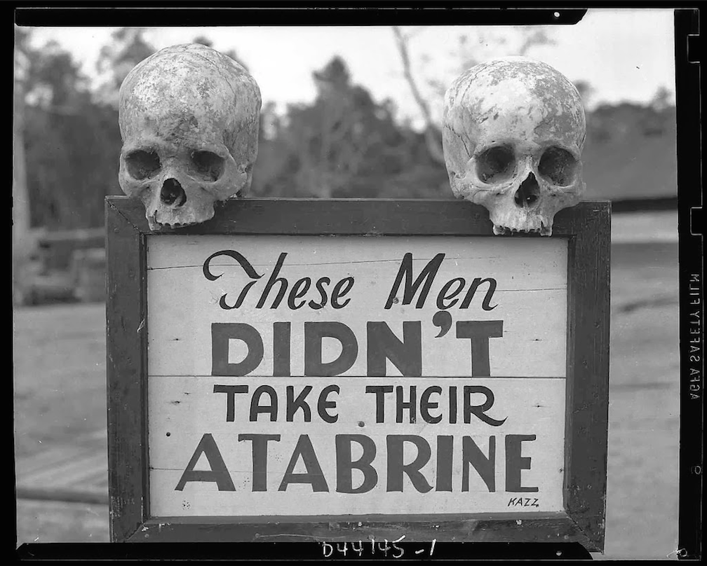 A sign posted at the 363rd Station Hospital in Papua New Guinea during World War II admonishes soldiers to take their antimalarials 