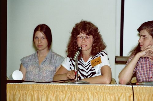 Trina Robbins speaks on a Women in Comics Panel at San Diego Comic Con, 1982. That year, the panel was populated with women from the independent comic scene, though superhero artist Jan Duursema sits to the left. (Alan Light/Wikimedia Commons)
