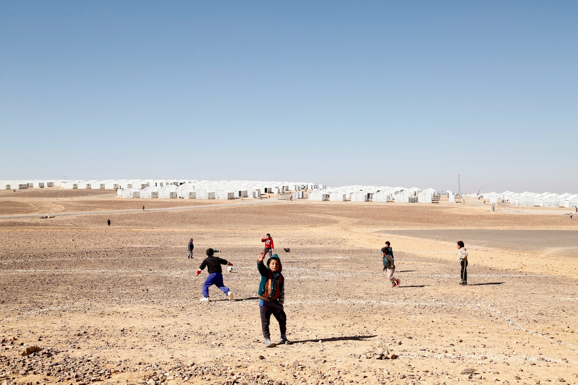 Syrian refugee children playing football near the Azraq camp in northern Jordan